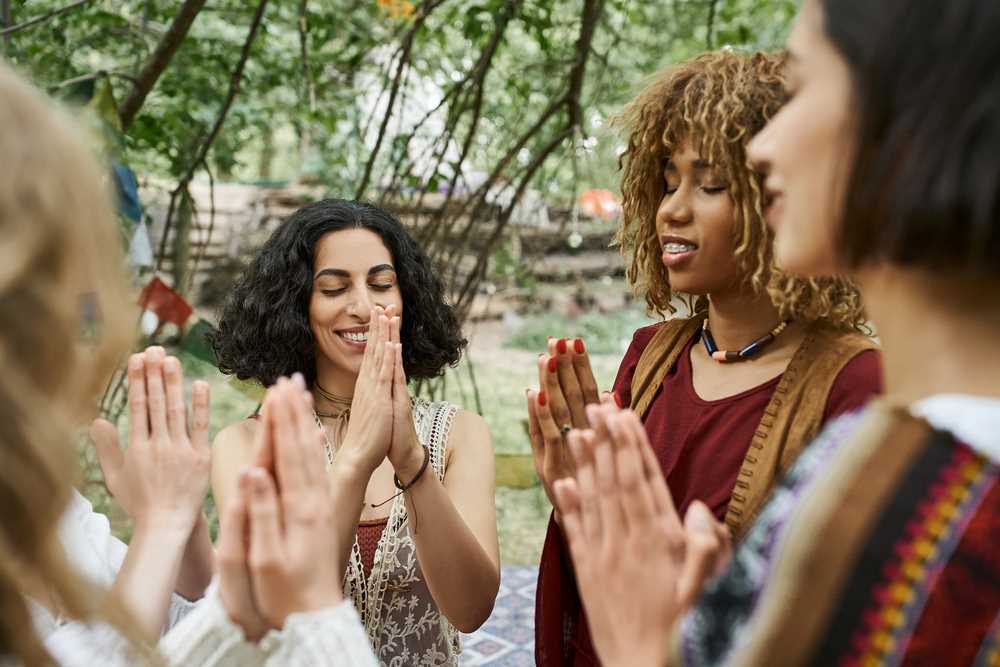 Image of smiling and stylish interracial women praying together outdoors, featuring 411 Business Law and highlighting 'Cultural and Language Barriers,' ensuring it aligns with the page's context.
