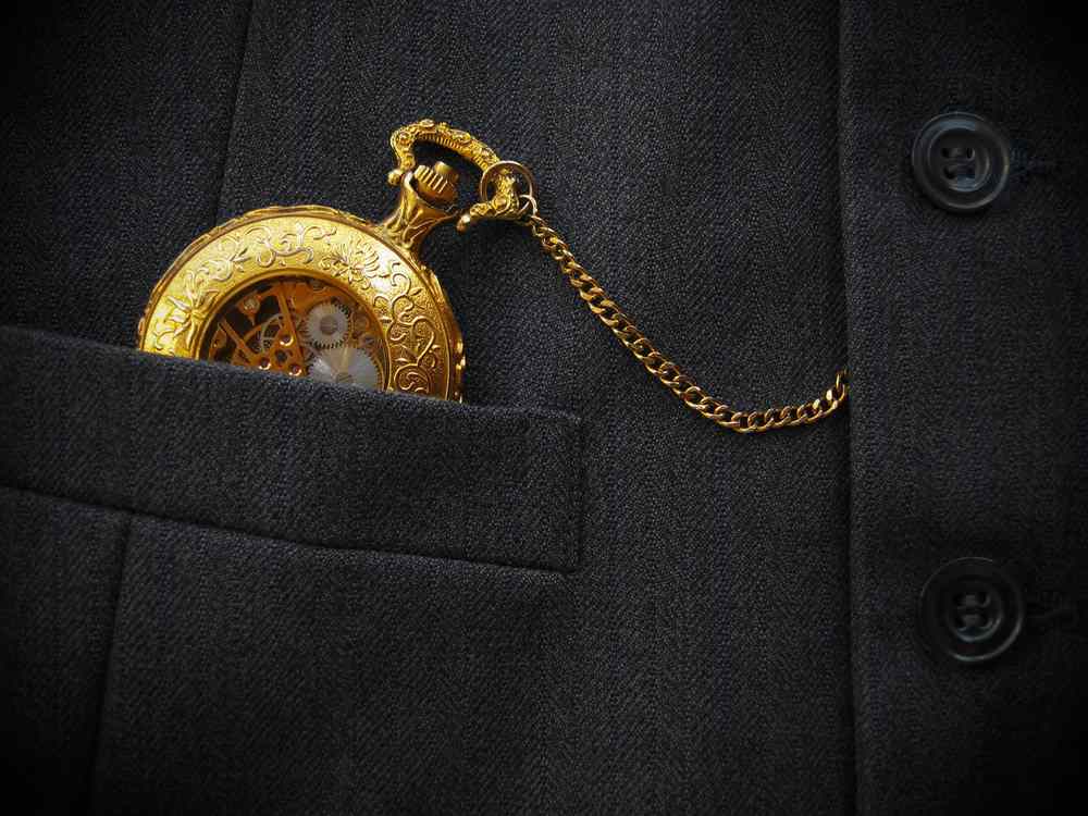 Golden pocket watch placed on a black men's waistcoat, featuring 411 Business Law, highlighting the concept of a Limited Liability Company (LLC) and aligning with the page's context.