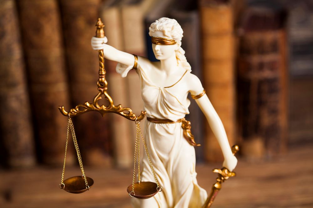 Image of a law concept with a wooden table background, featuring 411 Business Law and highlighting 'The Trial Process,' ensuring it aligns with the page's context.