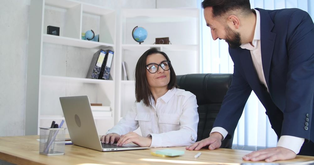 Portrait of a man and a woman in front of a laptop, featuring 411 Business Law, highlighting the topic 'What Is Business Formation and Structure?' and aligning with the page's context.